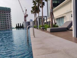 a swimming pool on top of a building with palm trees at Sunsuria Forum Soho by Diamond in Shah Alam