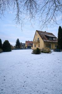a field covered in snow next to a house at Pension am Heckenacker in Rothenburg ob der Tauber