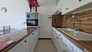 a kitchen with a sink and a microwave at O'Paloma - appartement T2 au port - Parking - Terrasse in Saint-Cyprien-Plage +5 photos