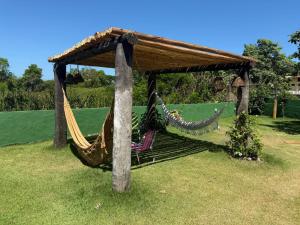 a hammock in a gazebo in a yard at Pousada Mangue Seco in Itaúnas