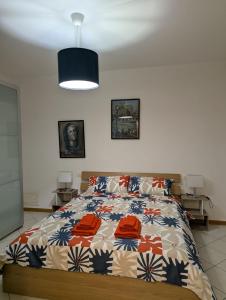 a bedroom with a bed with a colorful comforter at Il Centro Apartments 2 in Salsomaggiore Terme