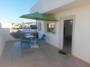 a patio with a table and chairs and an umbrella at Tunisia Queen Apartment in Hammamet