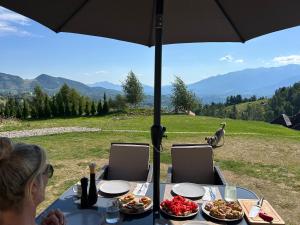 a woman sitting at a table under an umbrella at The Mountain View - no children in Peştera