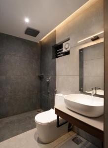a bathroom with a white sink and a toilet at Punarjeevani Ayurvedic Heritage in Vythiri +37 photos