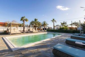 a swimming pool with chairs and a playground at Adonis Resort & Spa in Egina