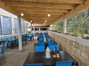an outdoor patio with blue tables and chairs at Villa BOTIĆ in Trogir
