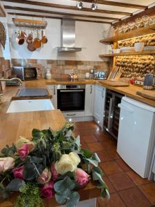 a kitchen with a counter with flowers on a table at Pet Friendly, Border Cottage, Norfolk in Briston +13 photos