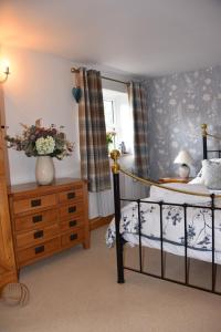 a bedroom with a bed and a vase of flowers at Pet Friendly, Border Cottage, Norfolk in Briston