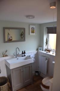 a bathroom with a sink and a toilet at Pet Friendly, Border Cottage, Norfolk in Briston