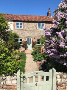 a white gate in front of a house at Pet Friendly, Border Cottage, Norfolk in Briston