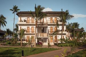 a large white building with palm trees in front of it at JAZ Elite Aurora in Michamvi