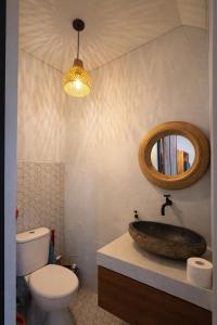 a bathroom with a sink and a mirror and a toilet at 2BR Villa Surrounded by Rice Fields Cemagi in Cemagi +16 photos