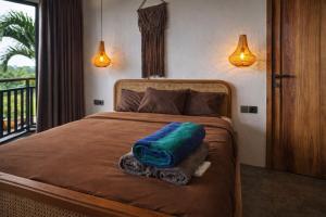 a bedroom with a bed with a green pillow on it at 2BR Villa Surrounded by Rice Fields Cemagi in Cemagi