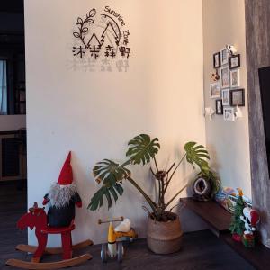 a room with a santa claus sitting on a chair and a plant at 沐光森野 一同永續旅行 中小型寵物友善 親子友善 in Wujie