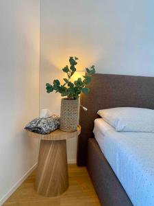 a table with a plant on it next to a bed at New and elegant luxury apartment in Kloten