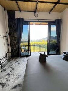 a bedroom with a bed and a large window at Khaosok Campsite in Khao Sok National Park