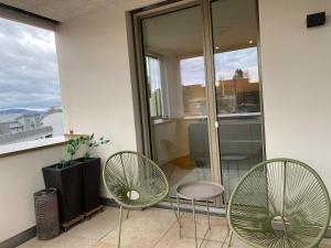 two chairs and a table in front of a window at New and elegant luxury apartment in Kloten