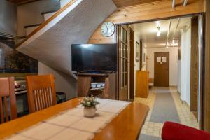 a dining room with a table and a clock on the wall at Apartment Dijak in Bohinj