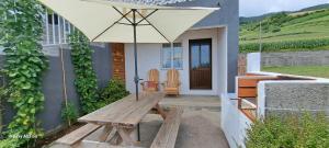 a picnic table with an umbrella in front of a house at Lar da Rita - One bedroom apartment in Água Retorta