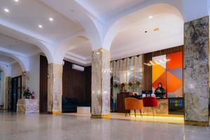 a lobby with columns and chairs in a building at Front One Hotel Mesir Surabaya in Surabaya +38 photos