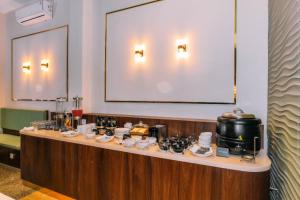 a long table with cups and dishes on it at Front One Hotel Mesir Surabaya in Surabaya