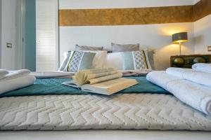a bed with a book and two books on it at Aquaemaris Apartment in La Maddalena