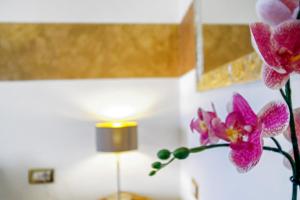 twoidium orchids in a vase next to a lamp at Aquaemaris Apartment in La Maddalena +33 photos