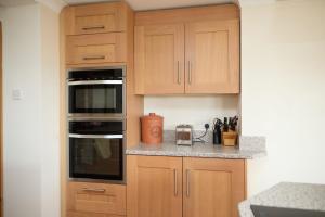 a kitchen with wooden cabinets and a counter top at Dukes Well in Congleton