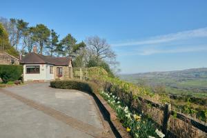 a house on a hill with a fence and flowers at Dukes Well in Congleton