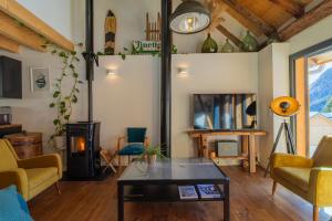 a living room with a table and yellow chairs at Alesina in Montricher-Albanne