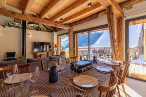 a dining room with a table and chairs with a view at Alesina in Montricher-Albanne