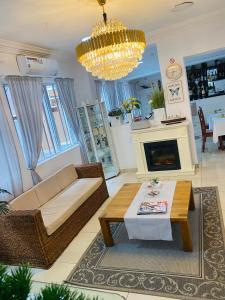 a living room with a couch and a table and a chandelier at Trevors Home Place in Lagos