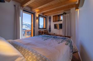 a bedroom with a bed and a large window at Alesina in Montricher-Albanne