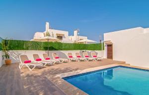 a swimming pool with chairs next to a house at Murta 26 in Sa Coma