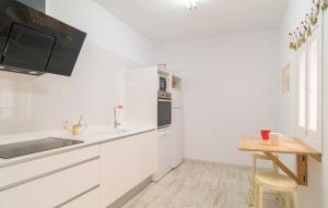 a kitchen with white cabinets and a wooden table at Convent in Alcudia