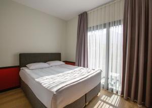a bedroom with a bed and a large window at Mediterrian Business Suites by HolidayKeys in Kyrenia