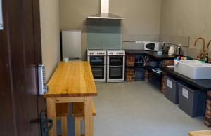 a kitchen with a wooden table in a kitchen at 3 Peaks Bunkroom in Settle