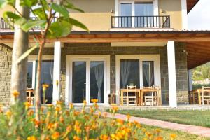 a house with sliding glass doors and a patio at Guesthouse Lumo & pool in Përmet
