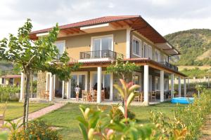 a house with a mountain in the background at Guesthouse Lumo & pool in Përmet