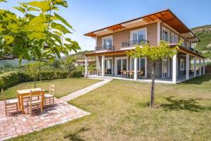 a house with a table and chairs in a yard at Guesthouse Lumo & pool in Përmet +57 photos