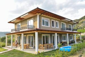 a house on a hill with a view of the ocean at Guesthouse Lumo & pool in Përmet