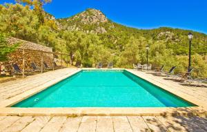 a swimming pool with chairs and mountains in the background at Biniforani Nou in Bunyola