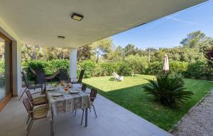 a patio with a table and chairs on a lawn at Amedart in Alcudia