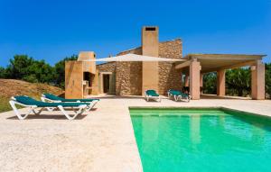 a villa with a swimming pool and two lounge chairs at Clovetes in Son Servera