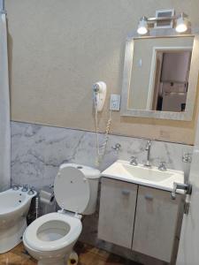 a bathroom with a toilet and a sink and a phone at Depto 09 Condominio Totoras in Federación