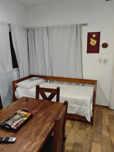 a room with two beds and a wooden table at Depto 09 Condominio Totoras in Federación