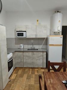 a kitchen with a sink and a microwave and a table at Depto 09 Condominio Totoras in Federación