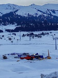 a snow covered field with a mountain in the background at Guest house grizzly in Dzhergalan