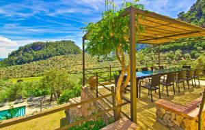 a patio with a table and chairs and a view of a mountain at Biniforani Nou in Bunyola +39 photos
