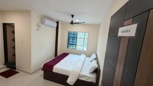 a small bedroom with a bed and a window at JJ Comfort Hotel in Turuvekere